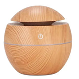A portable air humidifier with a wood grain finish and a blue LED light band, operating quietly while working.