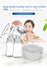 Double electric breast pump set with bottles and control base, mother and baby blurred in the background
