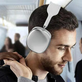 Modern silver Bluetooth headphones worn by male model in travel or commuting setting