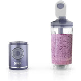 Portable blender motor base next to a 22 oz vessel filled with a purple smoothie