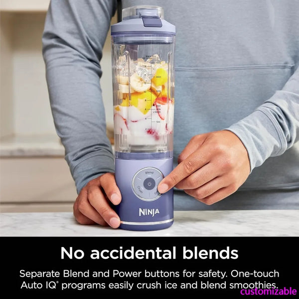 Hands pressing the blend button on a lavender cordless portable blender with fruit in the cup