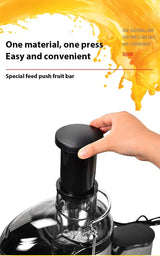 Hand pressing the pusher into the wide feed chute of the juicer