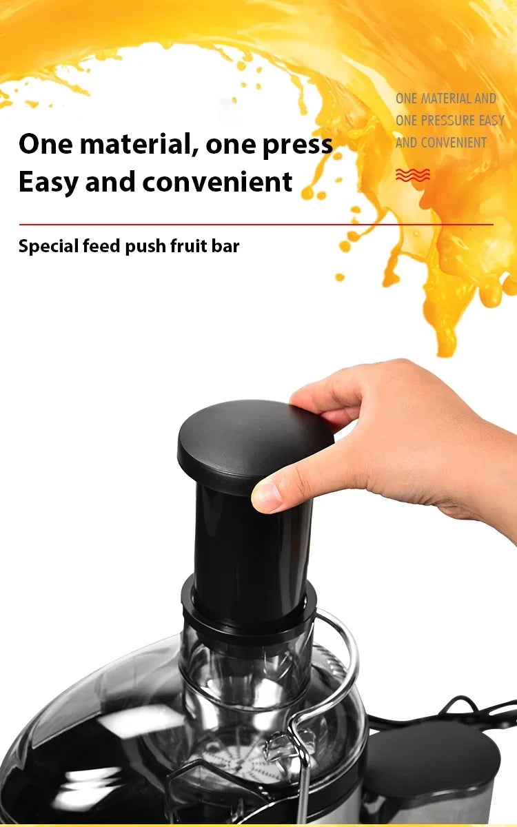 Hand pressing the pusher into the wide feed chute of the juicer