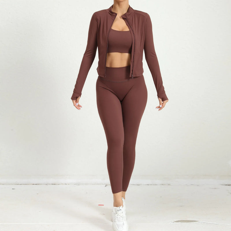 Brown yoga outfit with open jacket revealing matching crop top and high-waist leggings, athletic front pose.